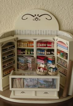 a dollhouse kitchen with lots of crafting supplies in it's cupboards