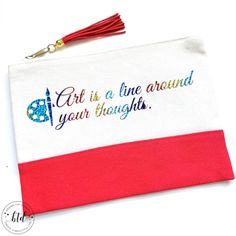 a red and white bag with a tassel on the side that says art is a line around your thoughts