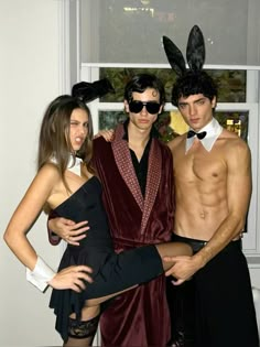 three people dressed up in costumes posing for the camera with one person wearing bunny ears