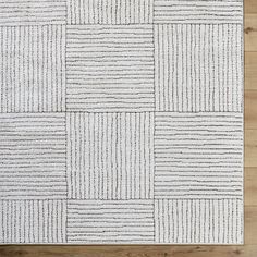 a white rug on top of a wooden floor