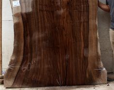 a man standing next to a large piece of wood