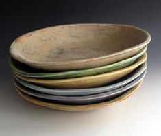 four bowls stacked on top of each other in different shapes and sizes, all with green rims