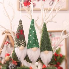 three christmas gnome ornaments hanging from a tree