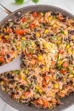 mexican rice and beans in a skillet with a spoon