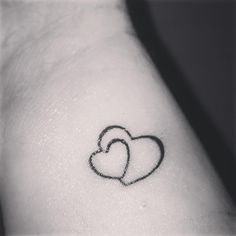 two hearts tattoo on the left side of the right arm, with one heart in the middle