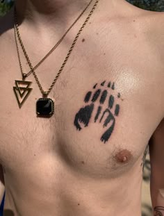 a man with a tattoo on his chest has a bear paw and triangle in it