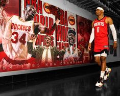 a basketball player is standing in front of a large poster with his name on it