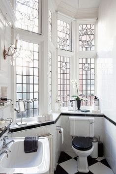 a bathroom with black and white tiles on the floor, tub, toilet and sink