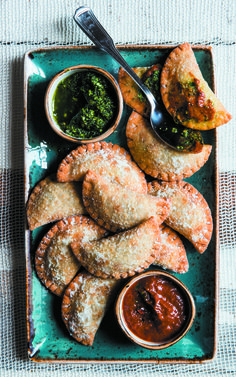 some food is sitting on a plate with dipping sauces