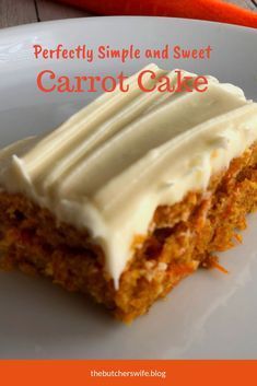 a piece of carrot cake with white frosting on a plate next to some carrots