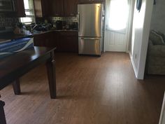 a kitchen with wood floors and stainless steel appliances