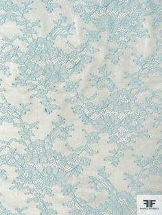 a white and blue lace fabric with flowers on it