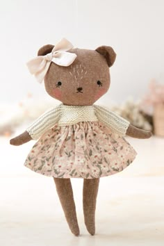 a brown teddy bear wearing a pink dress