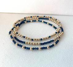 These beautiful bracelets are made of 14k gold filled beads and navy blue beads which come on a stretch cord to easily put on and take off. They're elegant, perfect for every occasion and make great gifts!  Patterns may vary slightly depending on wrist size. Gold filled beads size: 3MM Navy blue beads size: 2.5MM *FREE SHIPPING* Diy Elegant Bracelet, Blue And Gold Beaded Bracelets, Navy And Gold Jewelry, Navy Blue And Gold Jewelry, Navy Blue Beaded Bracelet, Navy Blue Bracelet, Elegant Beaded Jewelry, Blue Bracelet Ideas, Bracelet Ideas Gold