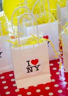 small bags with i love new york stickers are sitting on a red tablecloth