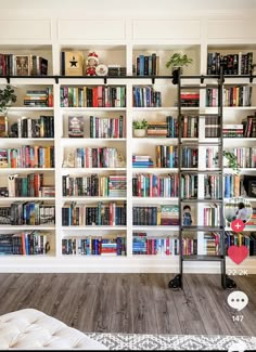 a book shelf filled with lots of books next to a white wall covered in shelves