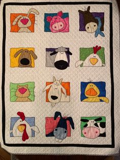 a quilted blanket with many different animals on it's sides and squares in the middle