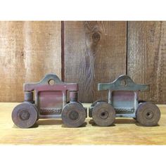 three metal toy trains sitting on top of a wooden table