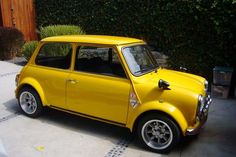 a small yellow car parked in front of a house