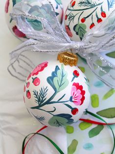 three christmas ornaments with bows on them sitting on top of each other, all decorated in different colors and patterns