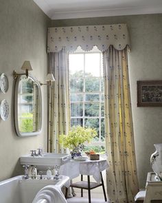 a bathroom with a sink, mirror and bathtub in front of a large window