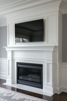 a white fireplace with a flat screen tv mounted on it's wall above the mantle