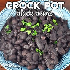 crock pot black beans with parsley in a blue bowl on a wooden table