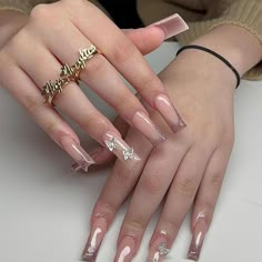 a woman's hands with long, shiny nails and gold rings on her fingers