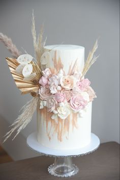 a white and gold wedding cake decorated with flowers