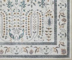 an old rug with birds and flowers on it's border in blue, green, yellow and white colors