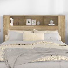 a bed with pillows and blankets on top of it next to a book shelf filled with books