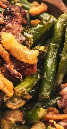 green beans, bacon and other vegetables in a wooden bowl on top of a table