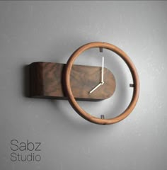 a wooden clock mounted to the side of a wall with a metal ring around it