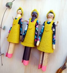 three wooden peg dolls sitting on top of a table