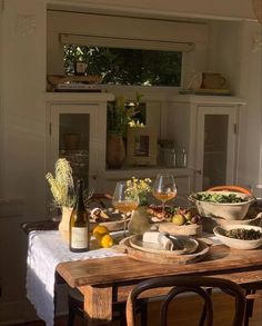 a wooden table topped with lots of plates and bowls filled with different types of food