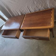 two wooden trays sitting on top of each other next to a roped off bed