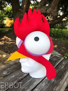 the head of a stuffed animal with a red and yellow rooster on it's face