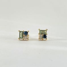 *THIS PAIR IS SOLD BUT CAN BE RE-MADE AS CUSTOM IF ORDERED BY 12/04/24* 18k yellow gold cluster stud earrings. Dainty and dazzling these stud earrings are set with a blue green mix of sapphires and diamonds. In the earrings there are 2mm x 4mm sage green sapphire baguettes, as well as royal blue round sapphires and a marquis cut white diamond. - 18k yellow gold - Blue Sapphire - Green Sapphire - White diamond Round Sapphire, Earrings Dainty, Unique Jewelry Designs, Green Sapphire, Jewelry Unique, Sapphire Earrings, Cluster Earrings, Diamond Cluster, White Diamond