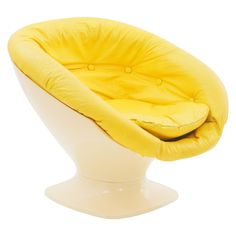 a white chair with a yellow cushion on it's back and foot rest in the shape of a ball