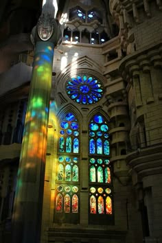 the inside of a building with many stained glass windows and lights coming from it's sides