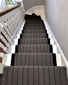 the stairs are lined with black and white carpet