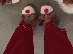 two teddy bears wearing red pants and santa hats with their feet propped up in the air