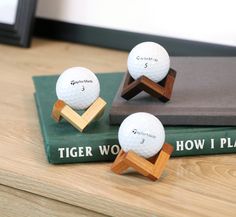 three golf balls sitting on top of a wooden stand