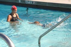 a woman in a swimming pool wearing a red hat