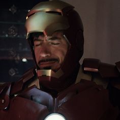 iron man standing in front of a window with his head turned to the side and eyes closed