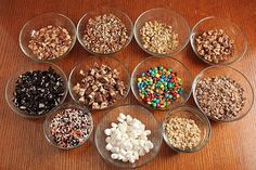 several bowls filled with different types of cereals and nuts on a wooden table top