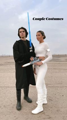 two people dressed up as characters from star wars standing in the desert with lightsabens