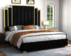 a bed with black and gold headboard in a white room next to a window