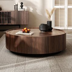 a living room with a round coffee table on top of a carpeted floor next to a window