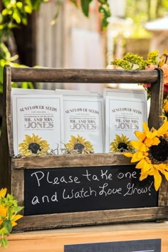 sunflowers and books are placed in an old wooden box with chalkboard on it